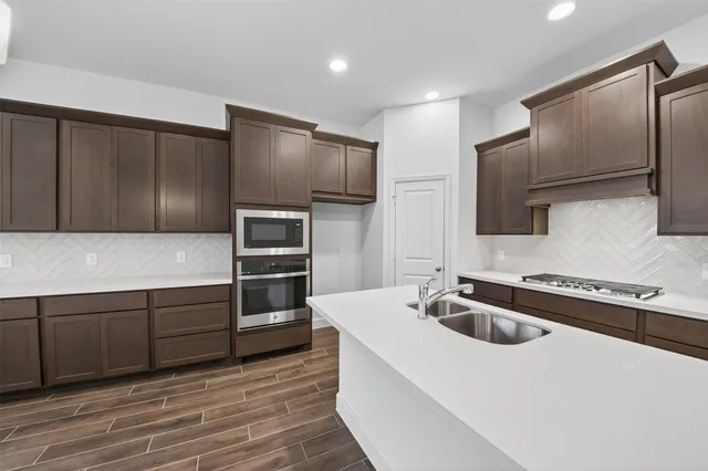 a kitchen with kitchen island a counter space a sink and stainless steel appliances