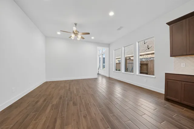 a view of a kitchen with wooden floor and a ceiling fan