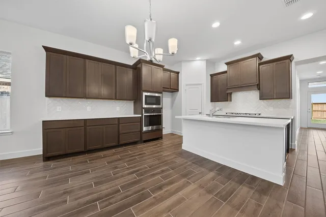 a view of cabinets a microwave oven a sink and dishwasher with wooden floor