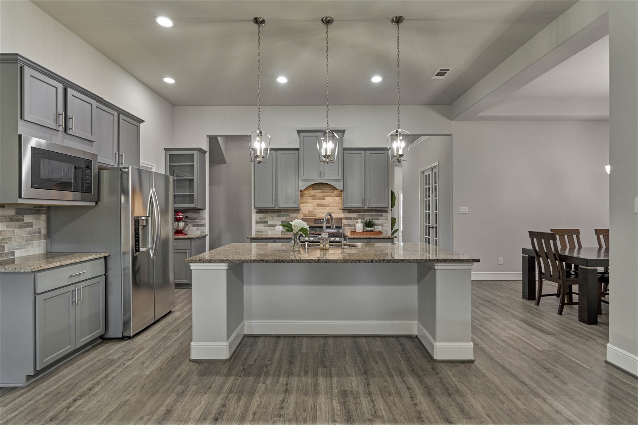 10660 Red Tail Place Conroe, TX 77385 - Photo 9 of 50 a view of a kitchen with kitchen island a counter top space stainless steel appliances and wooden floor