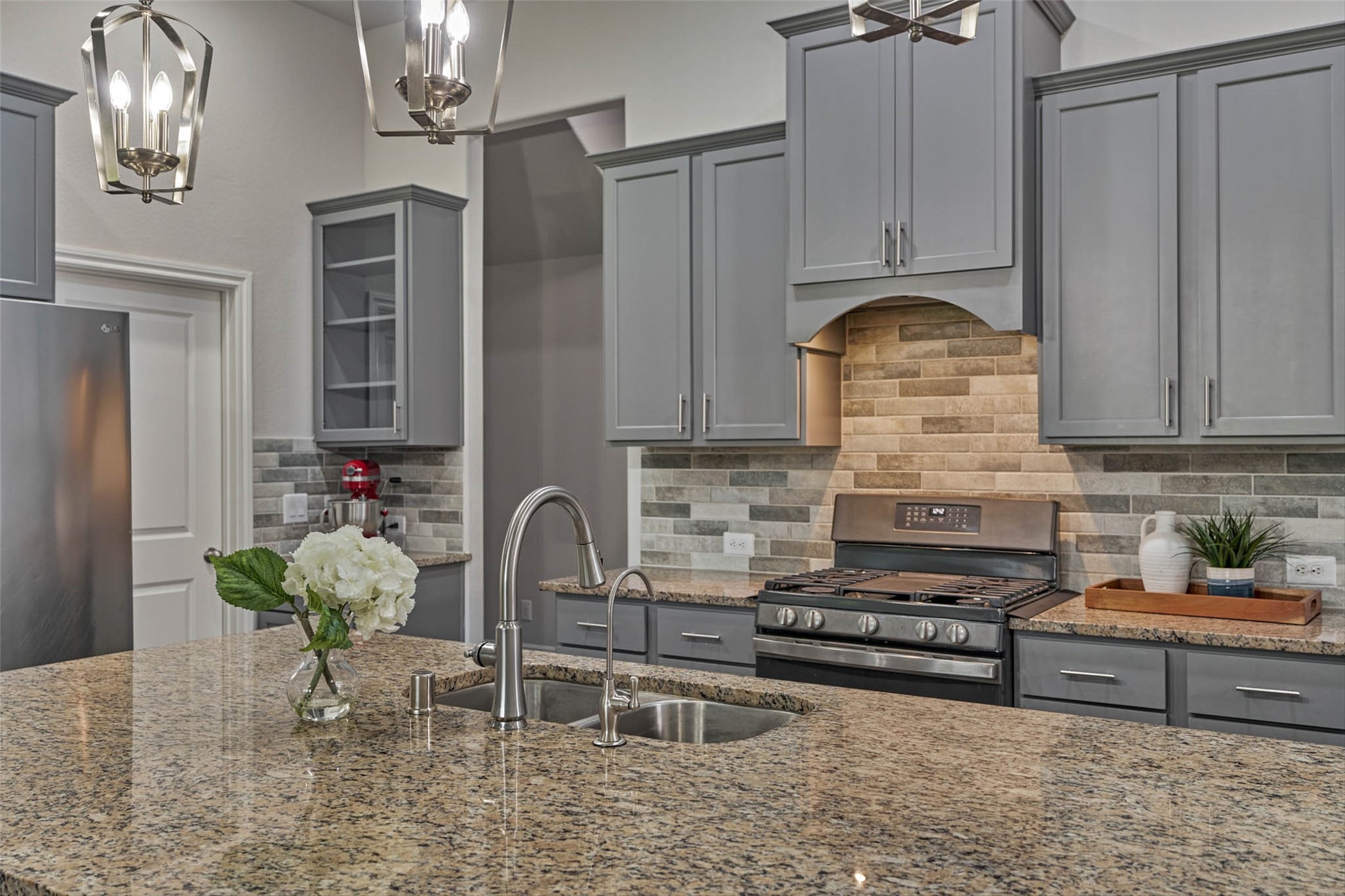 10660 Red Tail Place Conroe, TX 77385 - Photo 10 of 50 a kitchen with stainless steel appliances granite countertop a stove a sink and a refrigerator