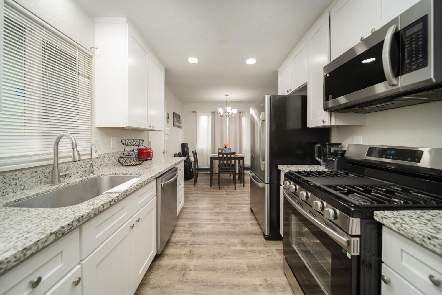 601 Summit Court Modesto, CA 95357 - Photo 5 of 17 a kitchen with stainless steel appliances granite countertop a sink stove and cabinets