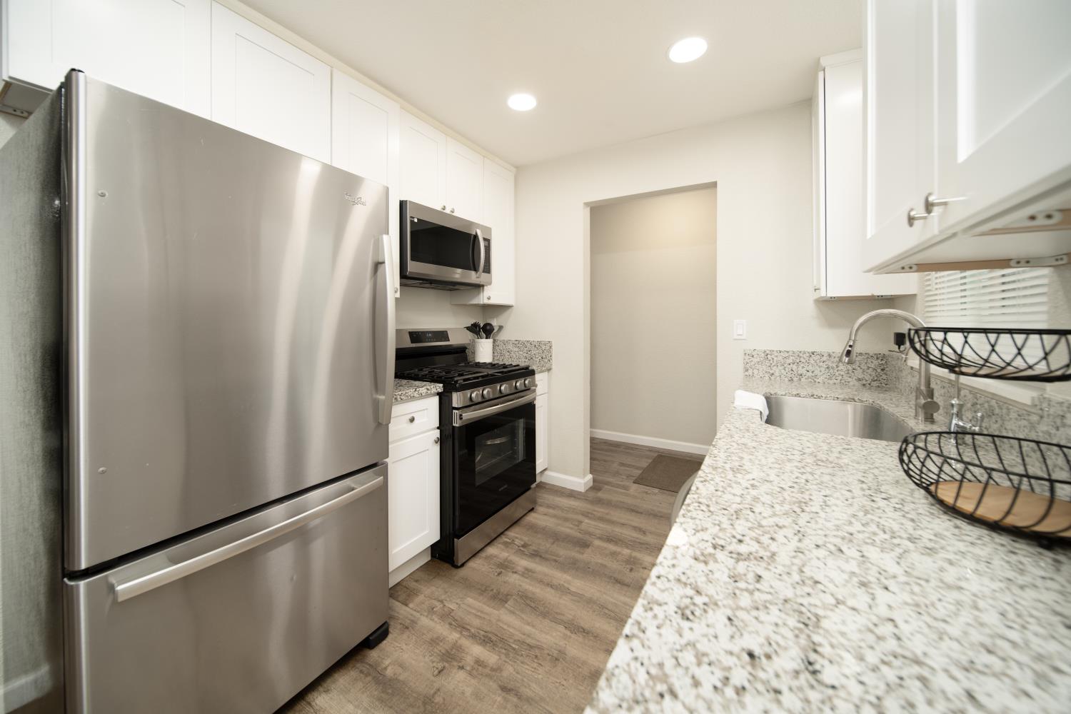 601 Summit Court Modesto, CA 95357 - Photo 6 of 17 a kitchen with stainless steel appliances granite countertop a refrigerator a stove and a sink