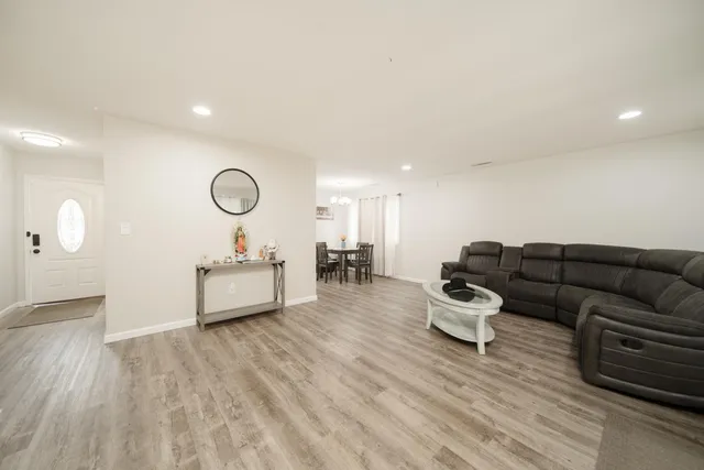 a living room with furniture and a wooden floor