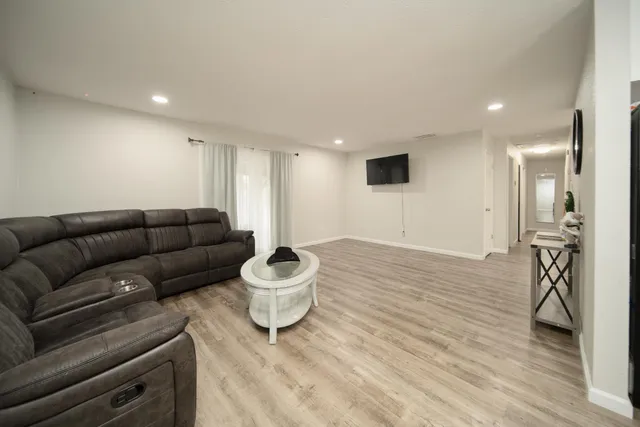 a living room with furniture and a wooden floor