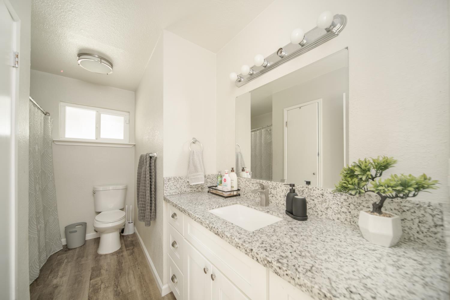 601 Summit Court Modesto, CA 95357 - Photo 10 of 17 a bathroom with a granite countertop sink a toilet and a mirror