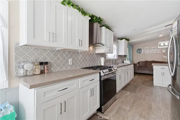 a kitchen with granite countertop white cabinets and white appliances