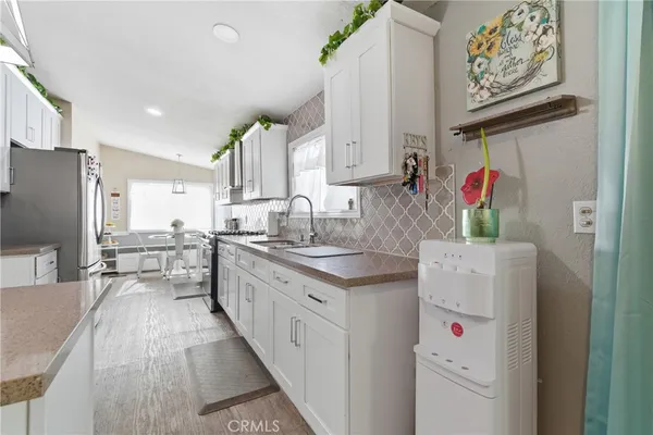 a kitchen with kitchen island sink stove and refrigerator