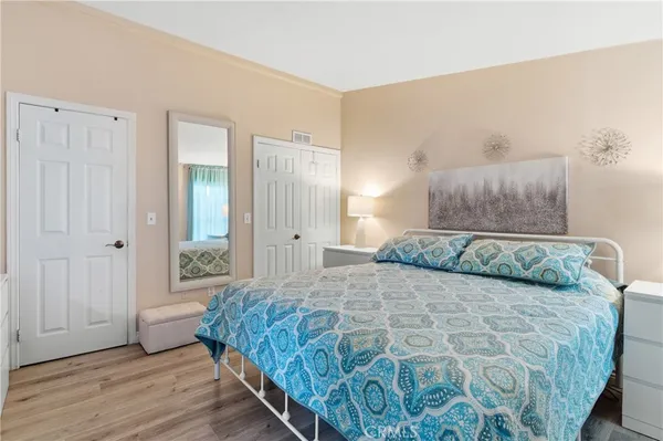 a bedroom with a large bed and a wooden floor