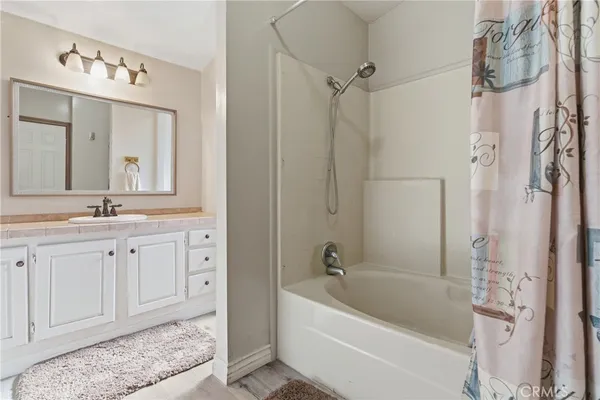 a bathroom with a tub a sink shower and mirror