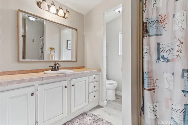 a bathroom with a double vanity sink mirror and toilet