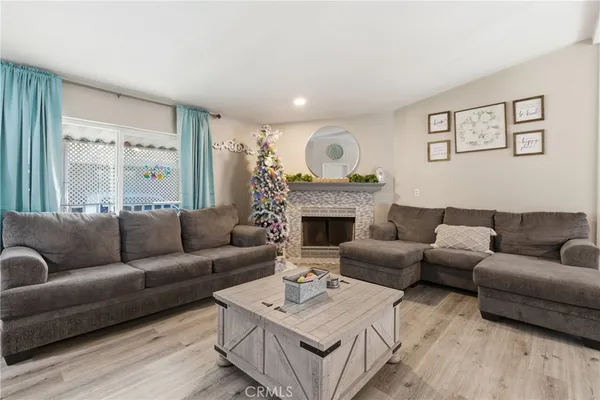 a living room with furniture a fireplace and a large mirror next to a window