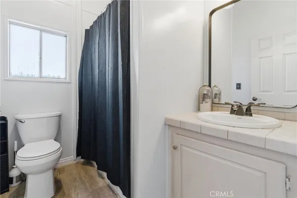 a bathroom with a sink a toilet and a mirror
