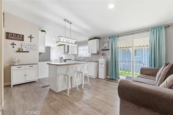 a living room with kitchen island furniture and a chandelier