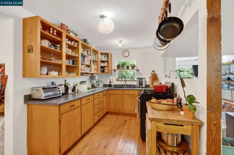a kitchen with stainless steel appliances a stove a sink cabinets and a window