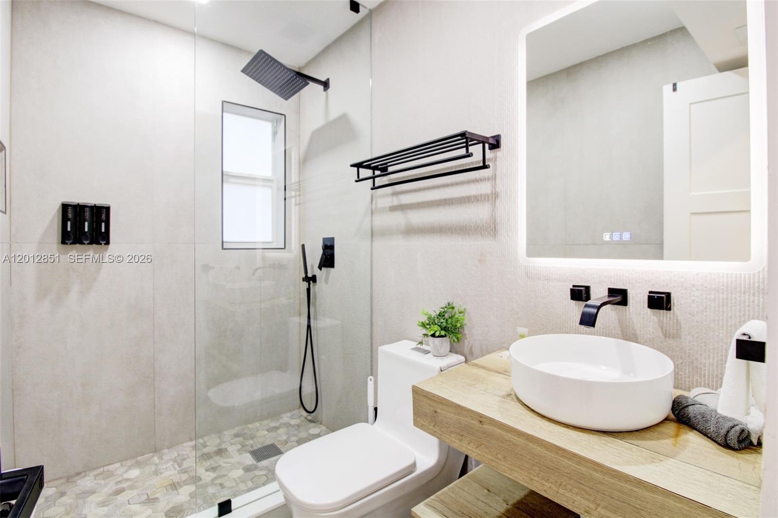 360 Northeast 116th Street Miami, FL 33161 - Photo 13 of 29 a bathroom with a granite countertop sink toilet a mirror and shower
