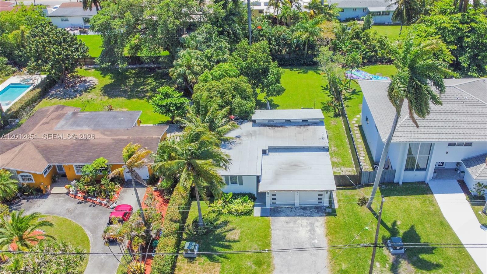 360 Northeast 116th Street Miami, FL 33161 - Photo 26 of 29 an aerial view of a house with swimming pool and large trees