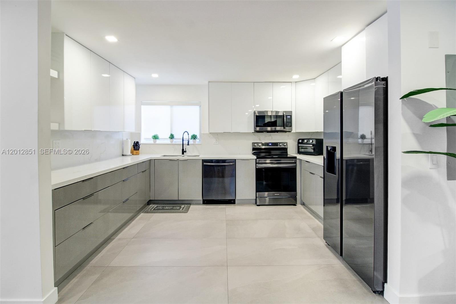 360 Northeast 116th Street Miami, FL 33161 - Photo 4 of 29 a kitchen with a sink stainless steel appliances and cabinets