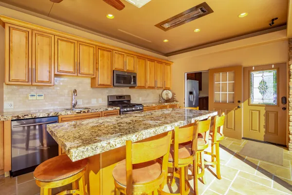 a living room with furniture kitchen view and a large window