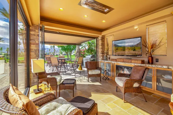 a kitchen with stainless steel appliances granite countertop a stove top oven a sink a dining table and chairs with wooden floor