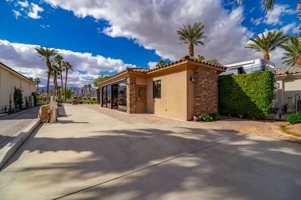 a view of a house with a yard and potted plants