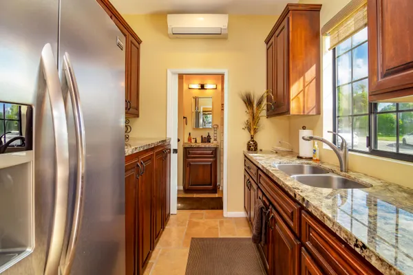 a bathroom with a granite countertop sink a mirror and shower