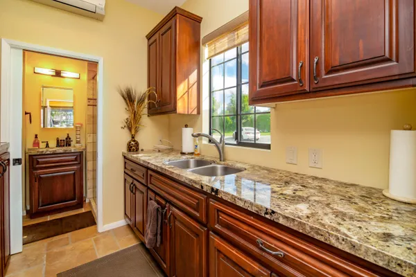 a bathroom with a granite countertop sink a mirror and shower