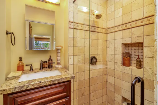 a kitchen with stainless steel appliances granite countertop a sink a stove and a wooden cabinets