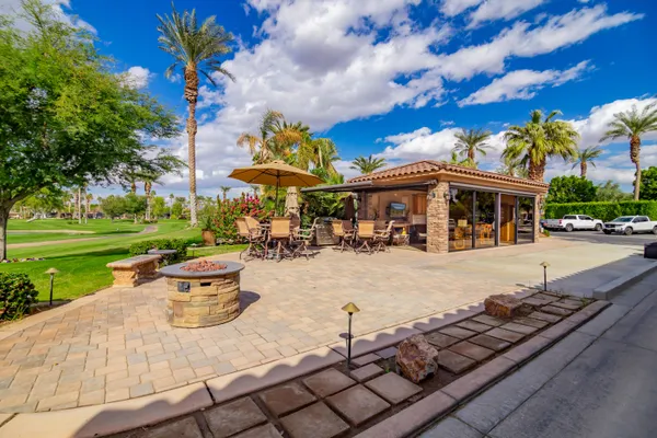 a view of a patio with a table and chairs and a barbeque