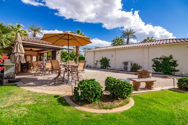 a view of a patio with a table and chairs under an umbrella