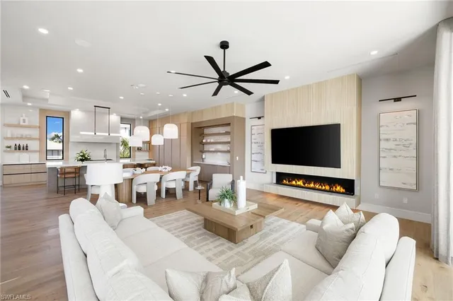 a living room with furniture and a flat screen tv with kitchen view