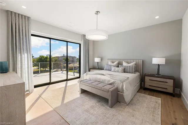 a bedroom with a large bed and a lamp next to a window