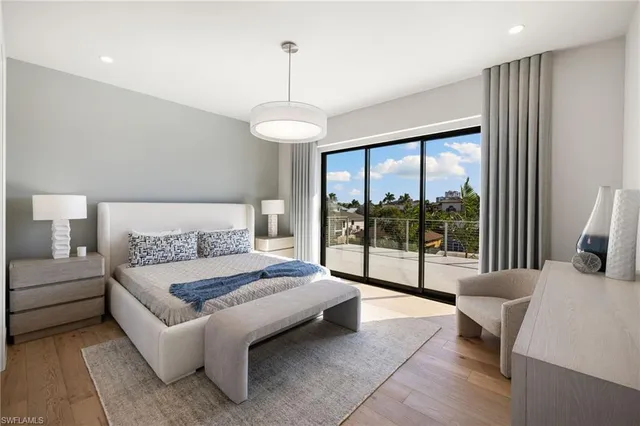 a spacious bedroom with a bed and glass walk in closet