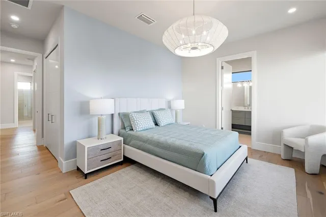 a spacious bedroom with a bed and a chandelier