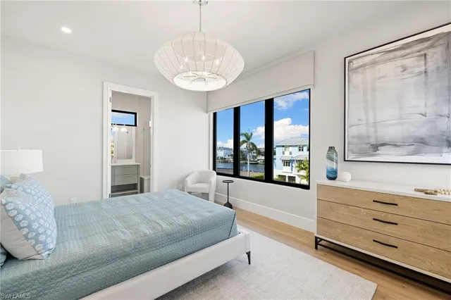 a bedroom with a large bed and a chandelier