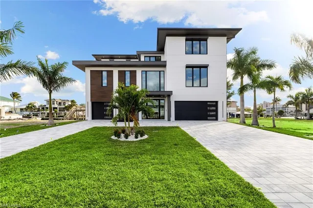 a front view of a house with a yard and palm tree