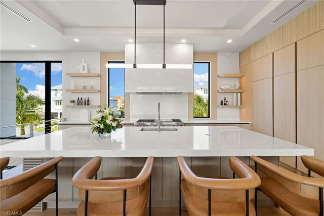 a kitchen with kitchen island granite countertop a table chairs stove and refrigerator