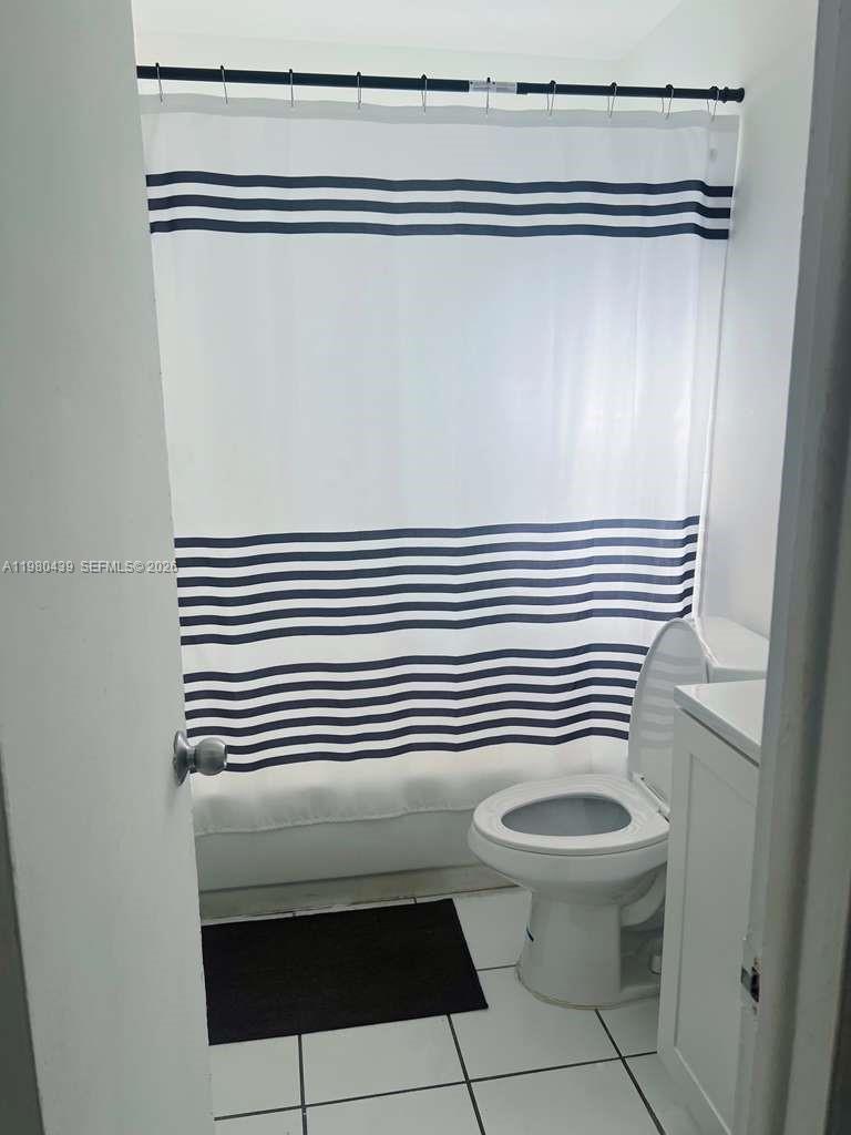 4435 Treehouse Lane, Unit H Tamarac, FL 33319 - Photo 18 of 18 a bathroom with a toilet a sink and mirror