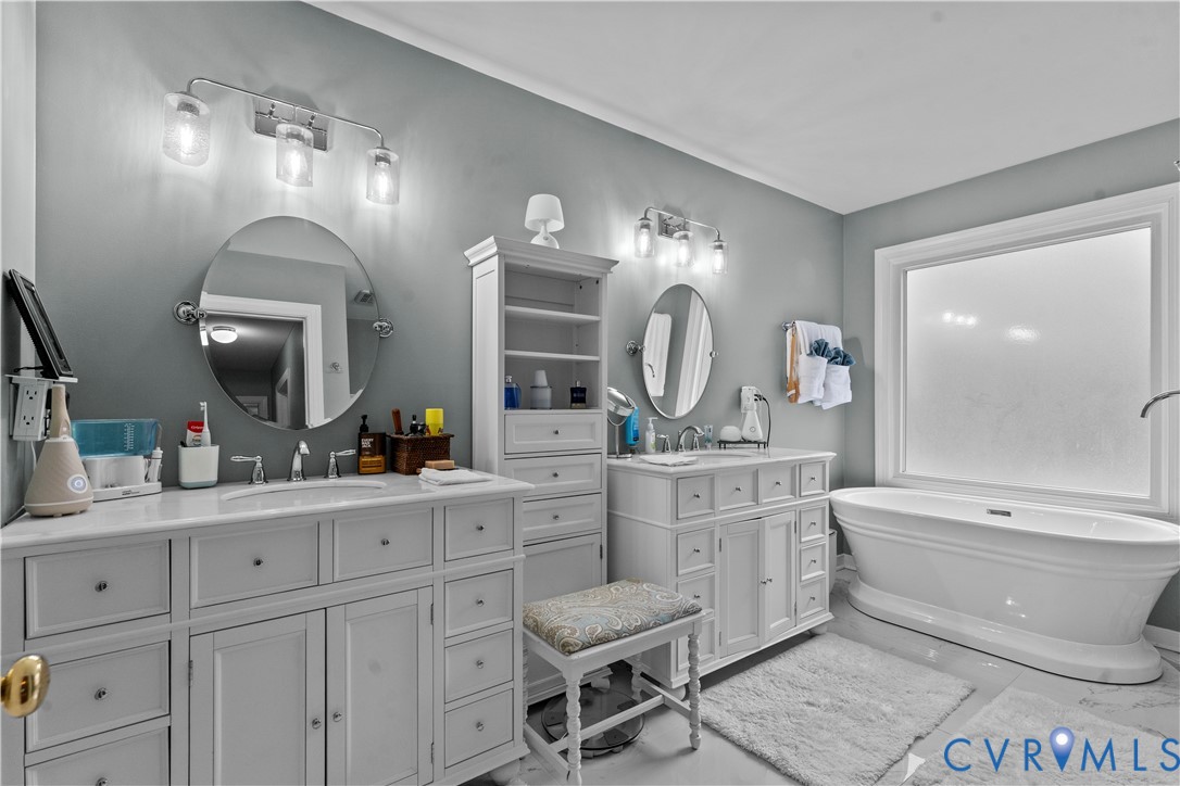 1937 Woodberry Mill Road Powhatan, VA 23139 - Photo 34 of 60 a spacious bathroom with a toilet a double vanity sink and a mirror