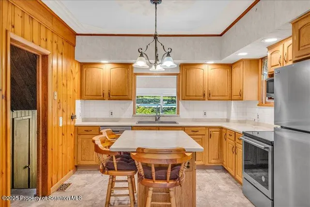a kitchen with stainless steel appliances granite countertop a sink a stove a refrigerator and island