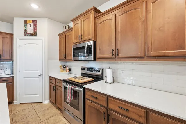 a kitchen with stainless steel appliances a stove microwave and refrigerator