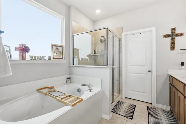 a bathroom with a tub a mirror and a shower