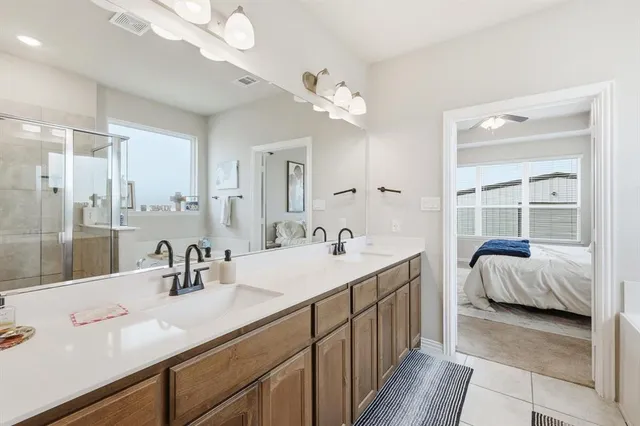 a en suite bathroom with double vanity a sink and a large mirror