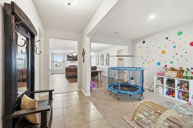 a living room with furniture and a baby crib