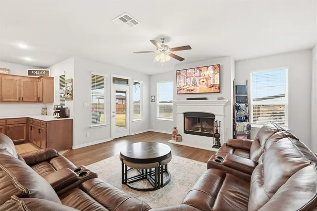 a living room with furniture a fireplace and a large window