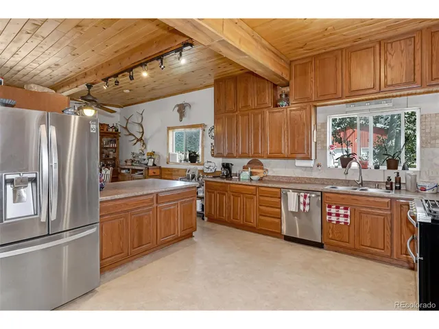 a kitchen with stainless steel appliances granite countertop a refrigerator a sink dishwasher a stove with wooden cabinets