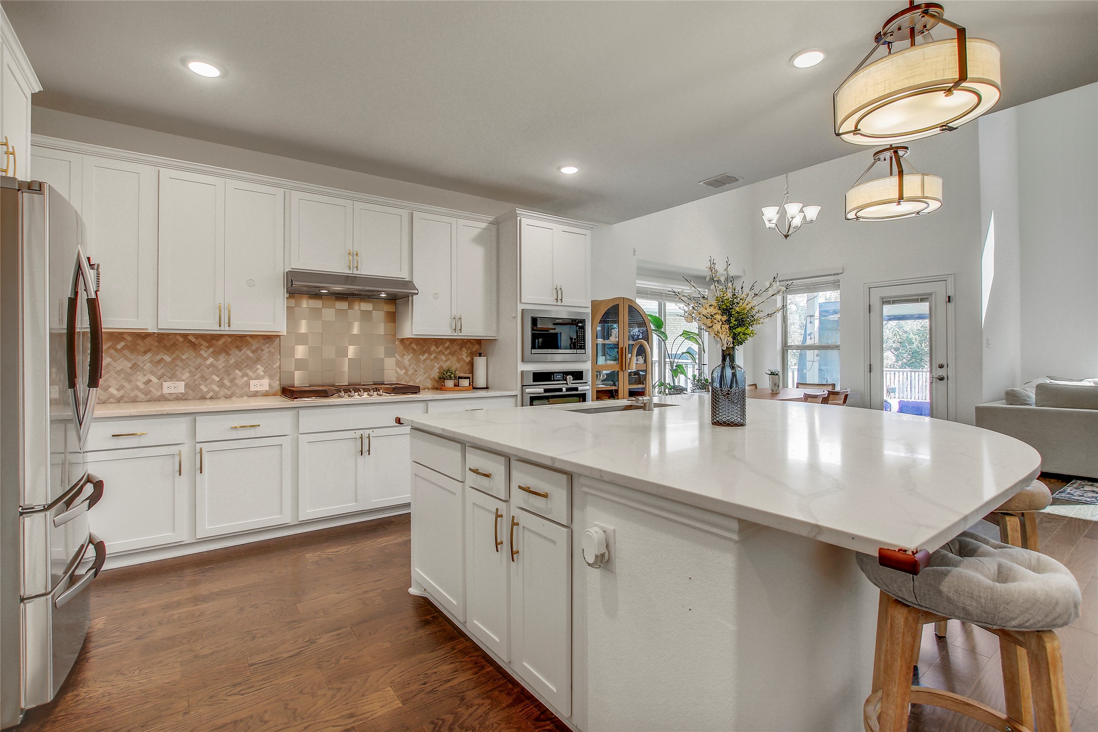 104 Millbend Road Georgetown, TX 78633 - Photo 10 of 40 A pristine kitchen offers a large island with bar seating, ample cabinetry, and rich hardwood flooring.