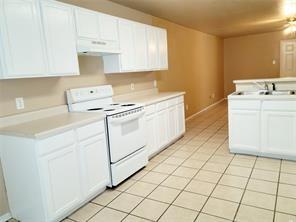 Kitchen featuring white cabinetry, light-toned countertops, a white electric range, and tile flooring