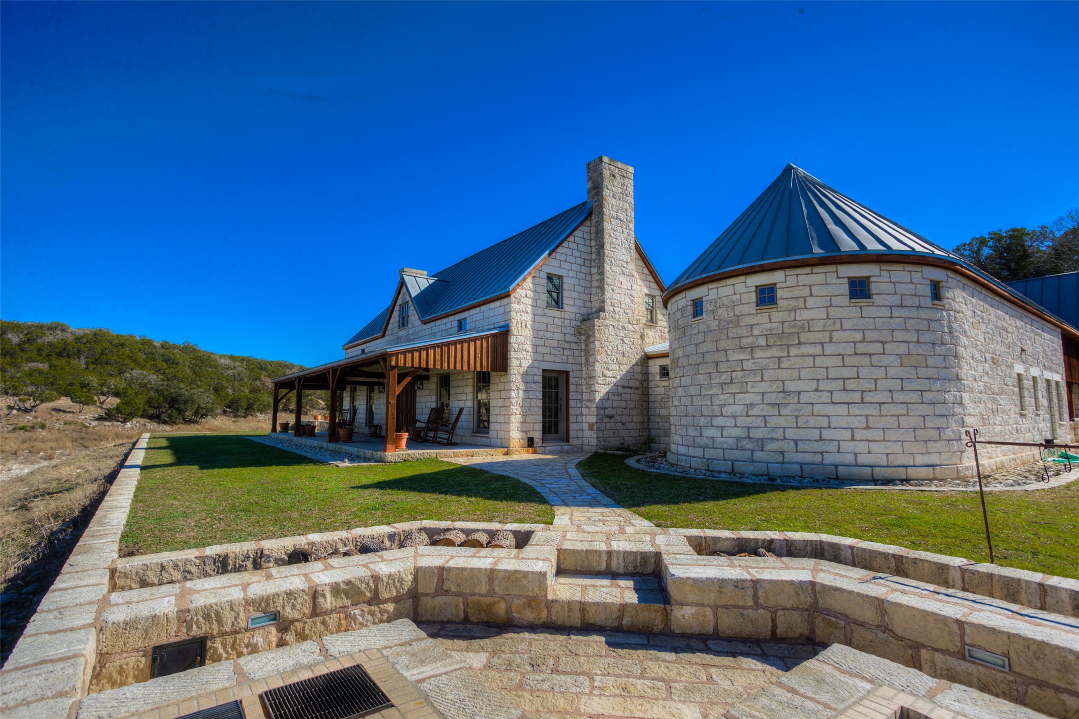 3777 Middle Creek Road Blanco, TX 78606 - Photo 11 of 40 Back of house featuring a standing seam roof, a lawn, a patio, and stone siding