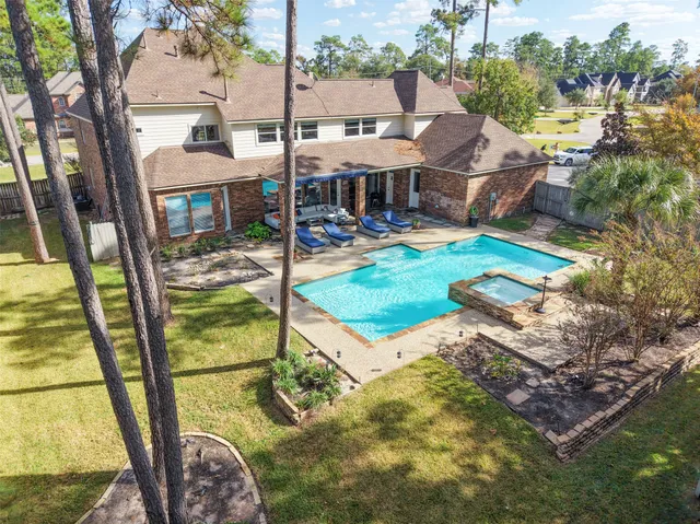 a view of swimming pool with seating area and trees in the background